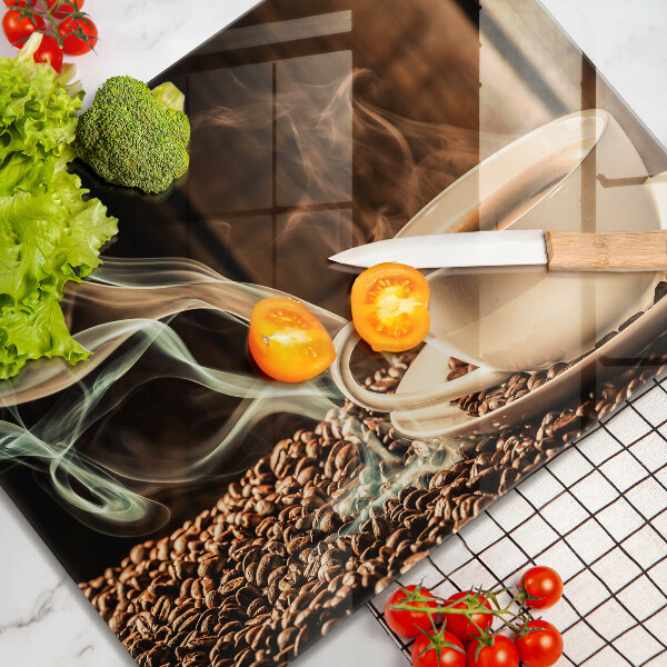 Tábua de corte de vidro Uma xícara e grãos de café