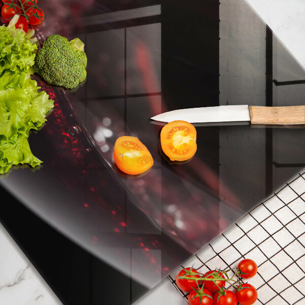 Tábua de corte de vidro Um copo de vinho tinto