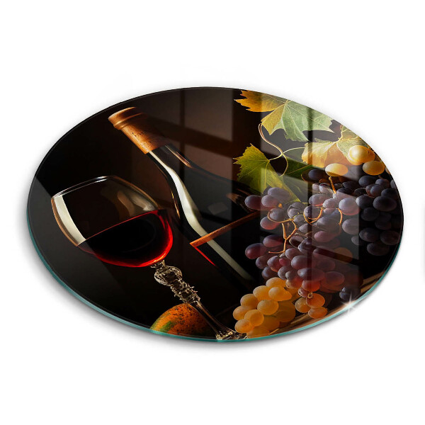 Tábua de corte de vidro Um copo de vinho e uvas