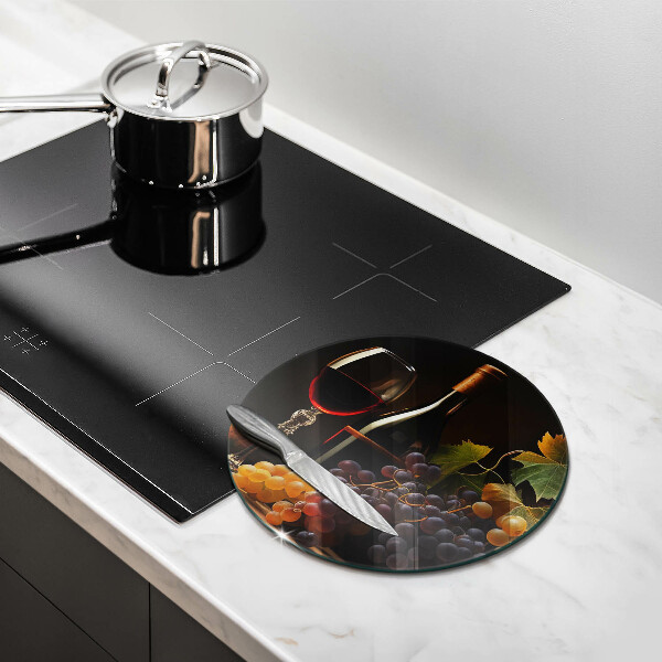 Tábua de corte de vidro Um copo de vinho e uvas