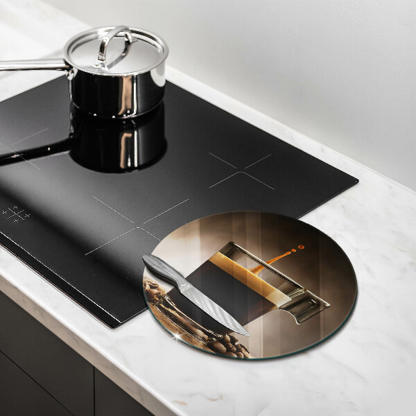 Tábua de cortar de vidro Um copo e grãos de café