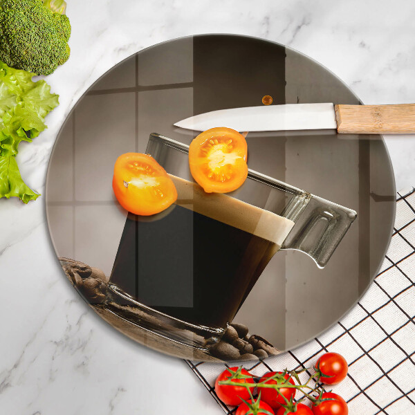 Tábua de cortar de vidro Um copo e grãos de café