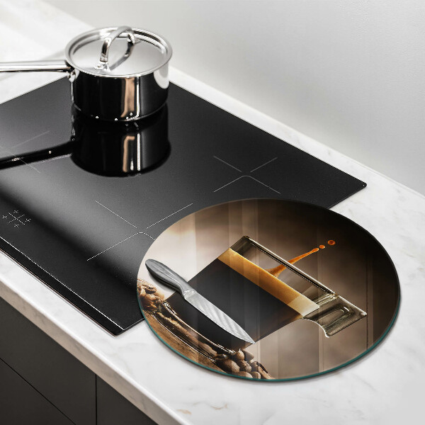 Tábua de cortar de vidro Um copo e grãos de café